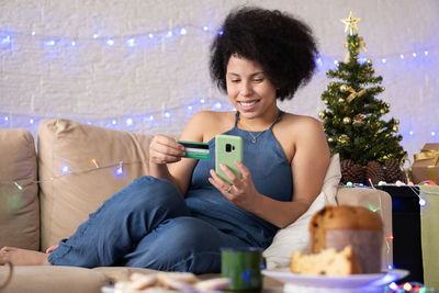 Smiling young woman using mobile phone