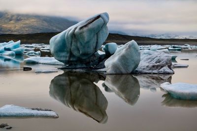 Frozen lake against sky during winter