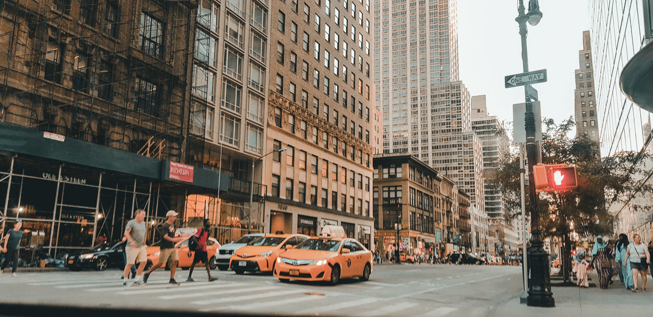 PEOPLE ON ROAD AGAINST BUILDINGS IN CITY