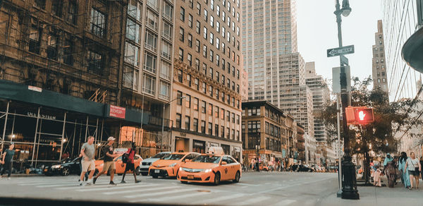 People on street amidst buildings in city