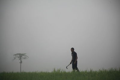 Man standing on field against sky