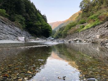 Scenic view of river amidst mountains against sky