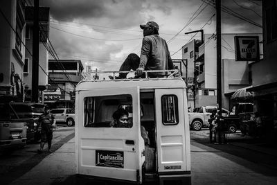 People on street against sky in city