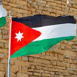 Low angle view of flag against brick wall