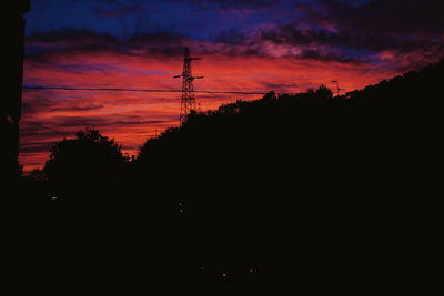 Silhouette of electricity pylon at sunset