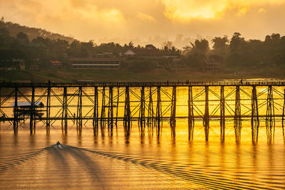 Bridge over river against sky during sunset