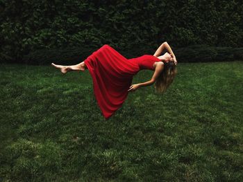 Digital composite image of woman wearing dress while lying in air over field