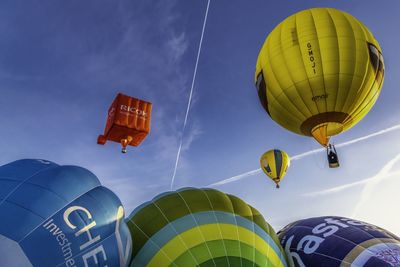 Low angle view of hot air balloons flying against sky