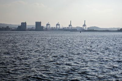 Scenic view of sea by buildings against sky