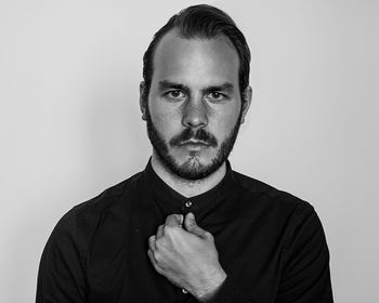 Portrait of confident man standing against wall