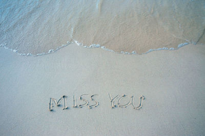 High angle view of text on sand at beach