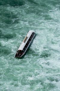 High angle view of ship sailing in rough water