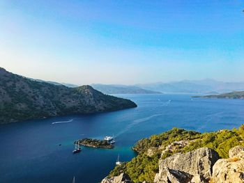 High angle view of sea and mountains against clear sky