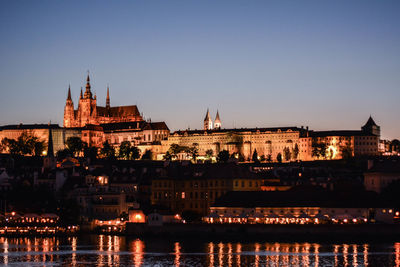 Illuminated buildings against sky at night