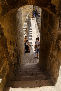 High angle view of people walking on steps amidst buildings