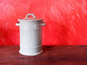 Close-up of empty coffee cup on table against wall