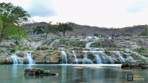 Scenic view of waterfall against sky