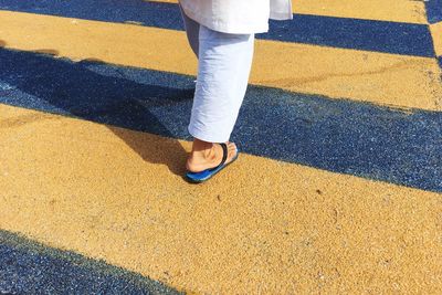 Low section of person standing on road