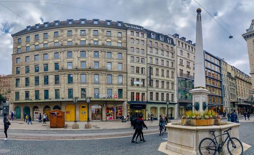 People walking on street against buildings in city