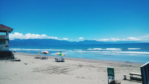 Scenic view of beach against blue sky