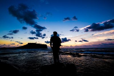 Silhouette of people standing on beach