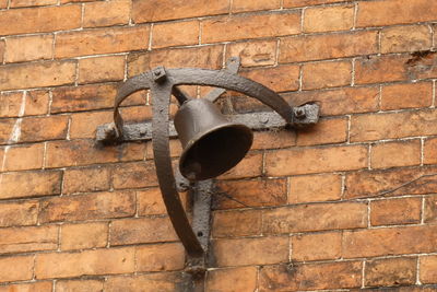 Low angle view of lamp mounted on brick wall