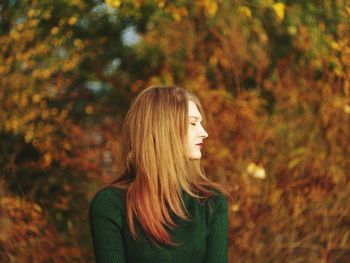 Young woman with eyes closed in park during autumn