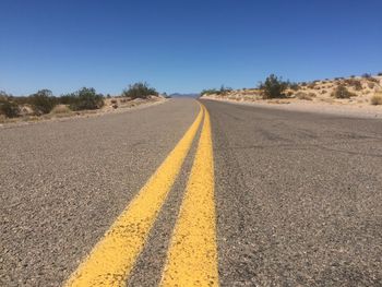 Road against clear blue sky