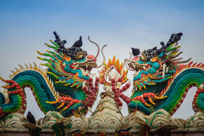 Low angle view of statue against sky at temple