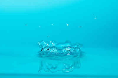 Close-up of water splashing on blue surface