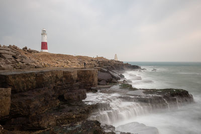 Long exposure of the tide flowing over rocks on the beach at portland bill lighthouse in dorset