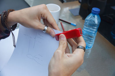 Cropped hands of woman stapling paper