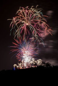 Low angle view of firework display at night