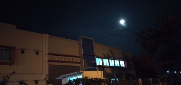 Low angle view of illuminated buildings against sky at night