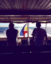 Rear view of man and woman sitting in boat