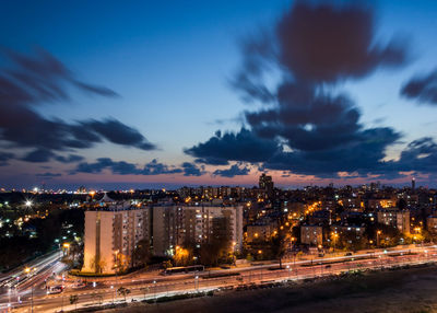 Illuminated cityscape against sky at night