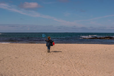 Rear view of boy at beach