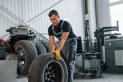  man in uniform is working in the auto service.