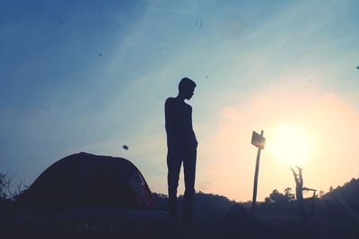 Silhouette man standing against sky during sunset