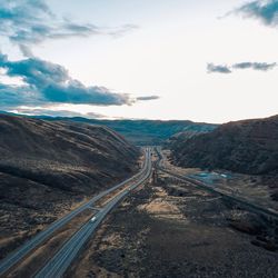 Empty road along landscape and mountains against sky