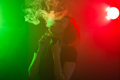 Side view of woman with red light against colored background