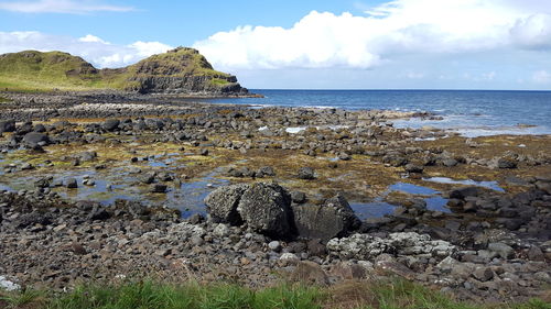 Rock formation on beach against sky