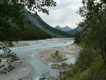 Scenic view of river against cloudy sky