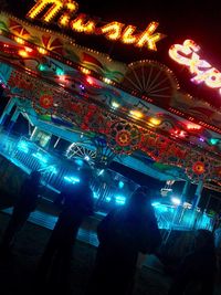 Illuminated ferris wheel against sky at night