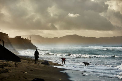 People on beach against sky