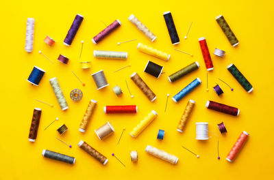 Directly above shot of multi colored pencils over yellow background