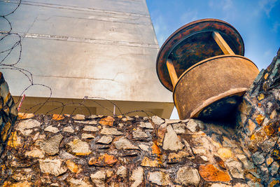 Low angle view of old rusty metal against sky