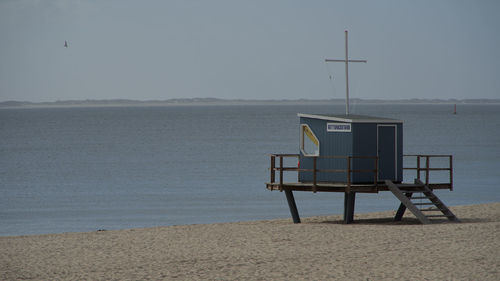 Lifeguard hut on beach against sky