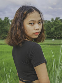 Portrait of teenage girl on field