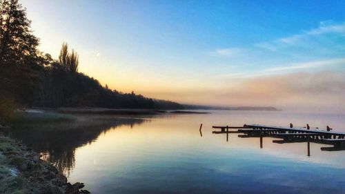 Scenic view of lake against sky at sunset